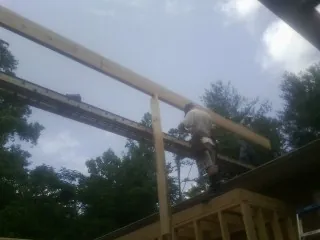 Carpenter setting a ridge beam over a new addition frame — Ice Dam Removal by Roofing Brothers in Joanna