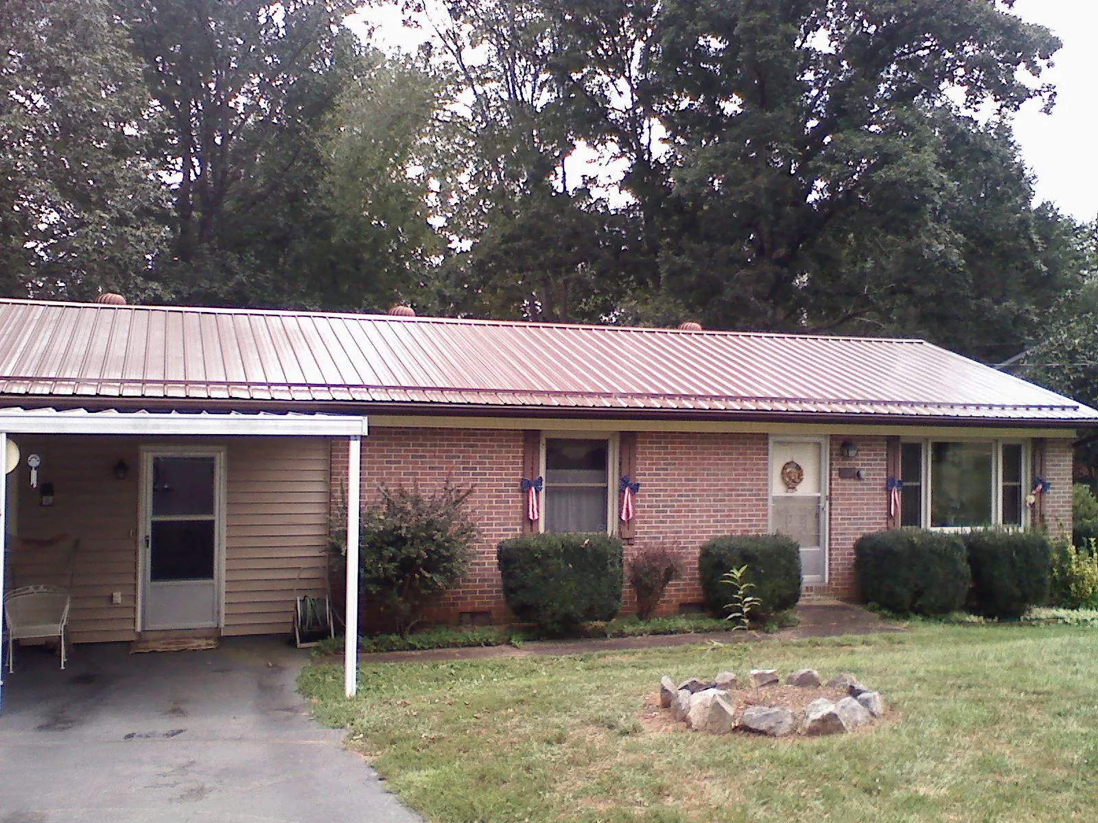 Bronze metal roof and carport on a brick ranch home — Roof Repair work by our crew in Joanna