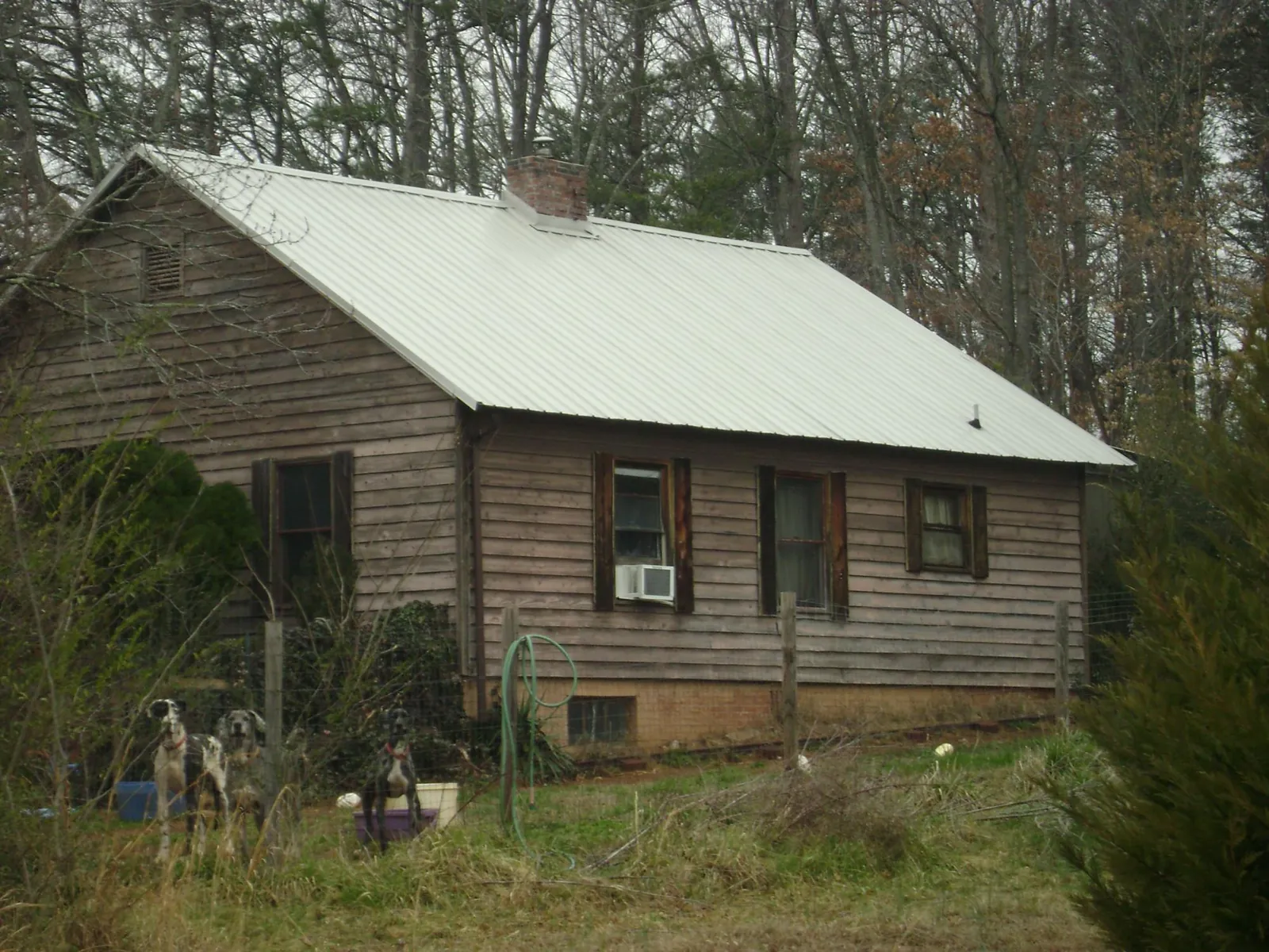 White metal roof on an old wood sided farmhouse, from a Metal Roof Installation job in Joanna